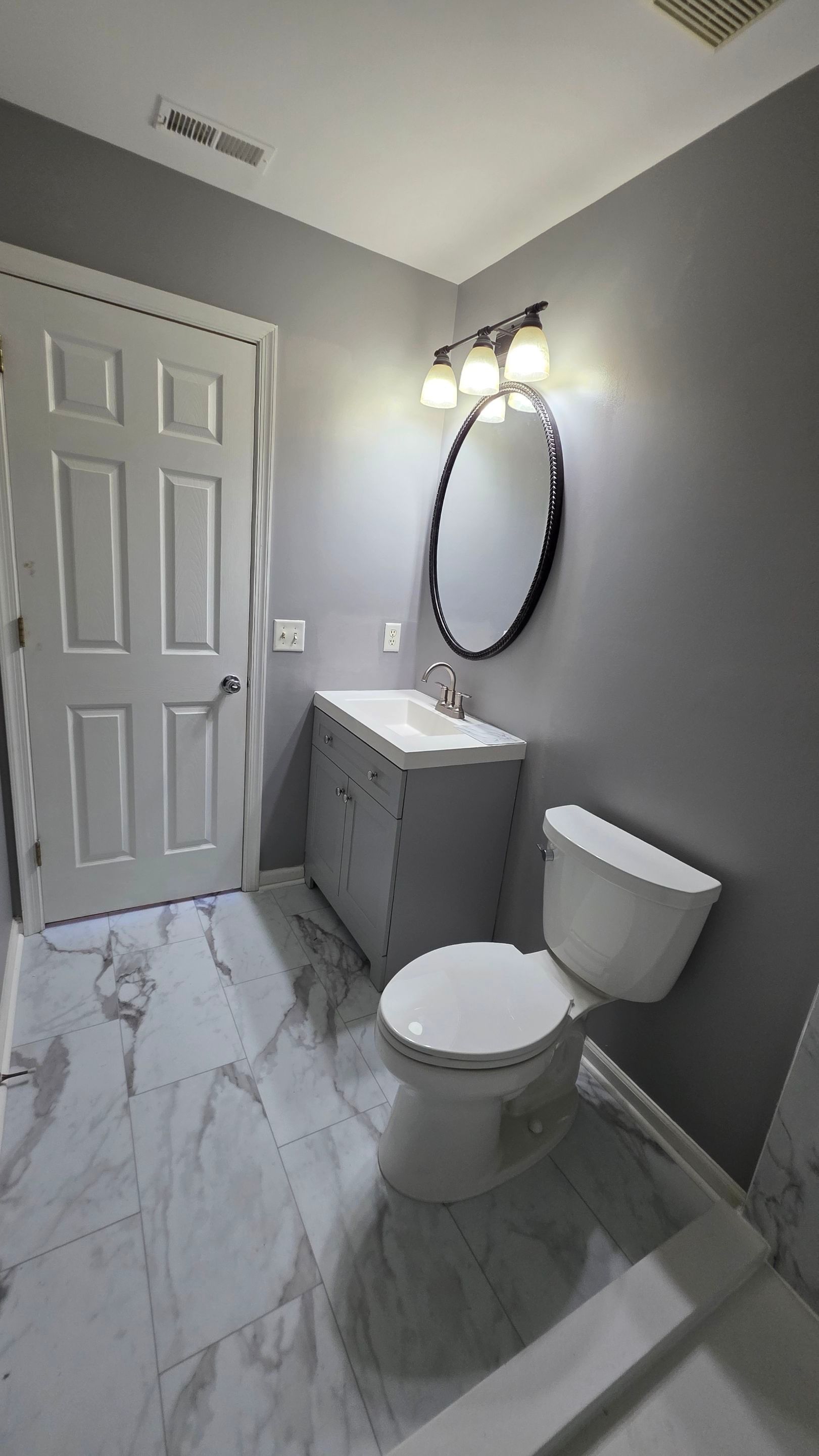 Gray bathroom remodel by Elixtro Renovations